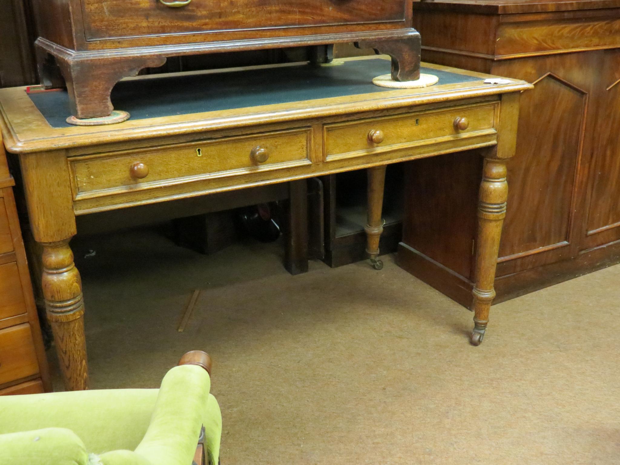 A Victorian oak writing table, with two frieze drawers, on turned legs with casters, 4ft.