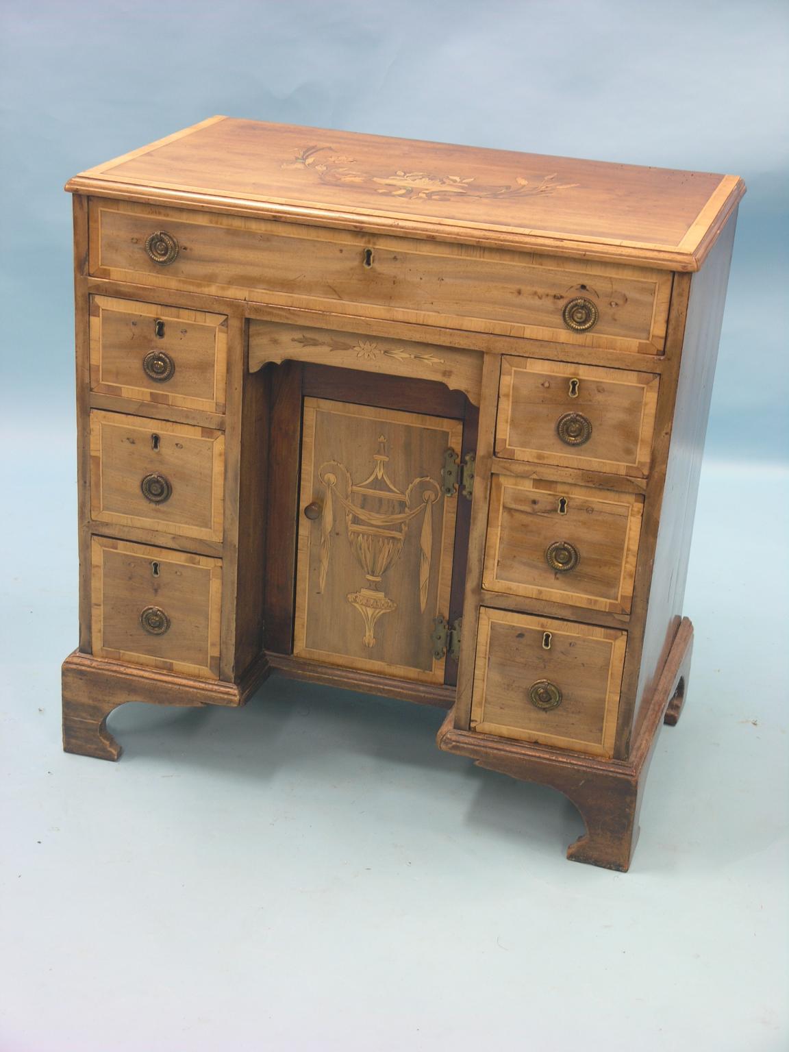 A 19th century inlaid and banded mahogany kneehole pedestal desk, in George III taste, having a