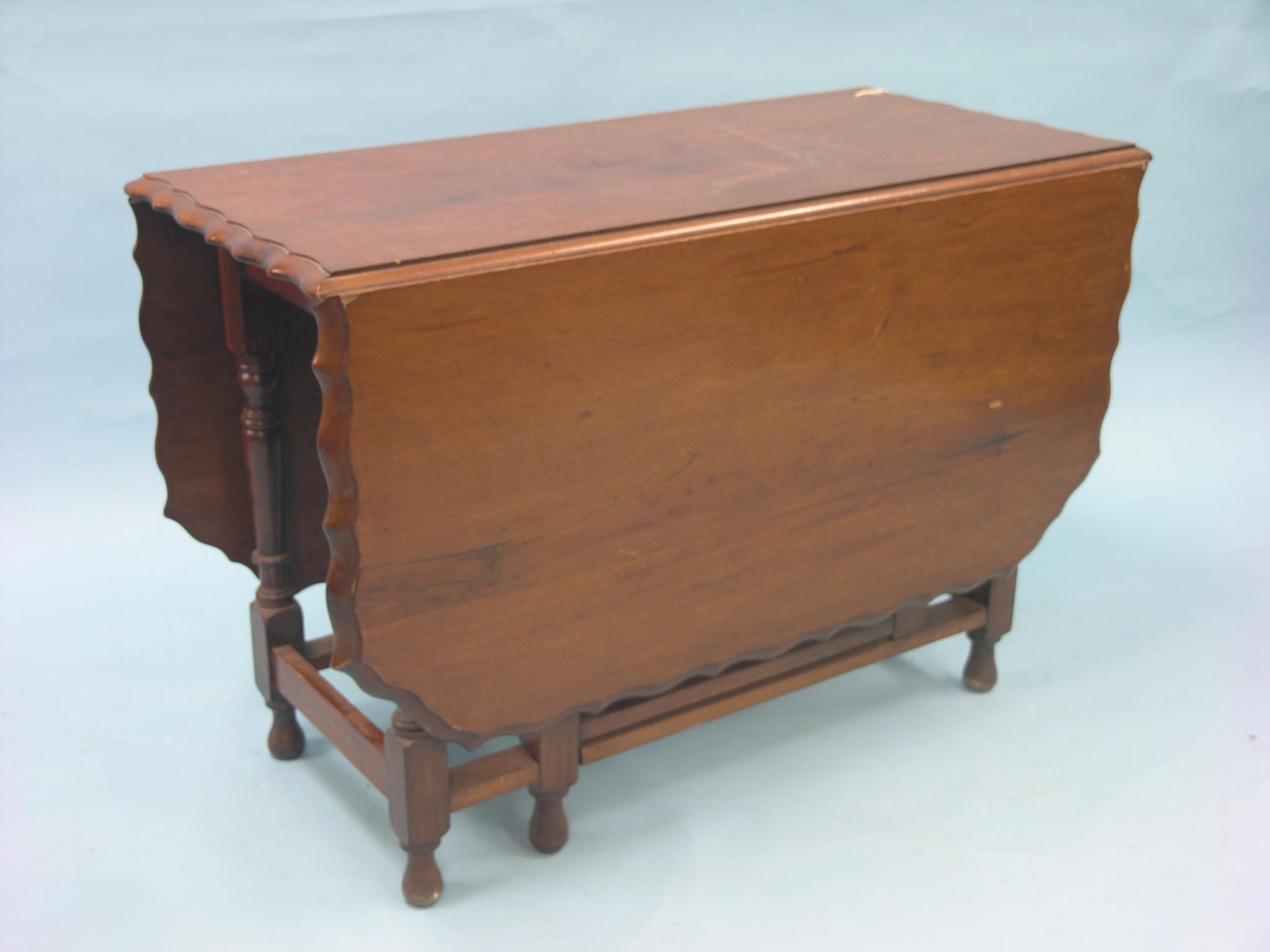 A mahogany drop-leaf dining table, with shaped border, on turned underframe, 3ft. 5in.