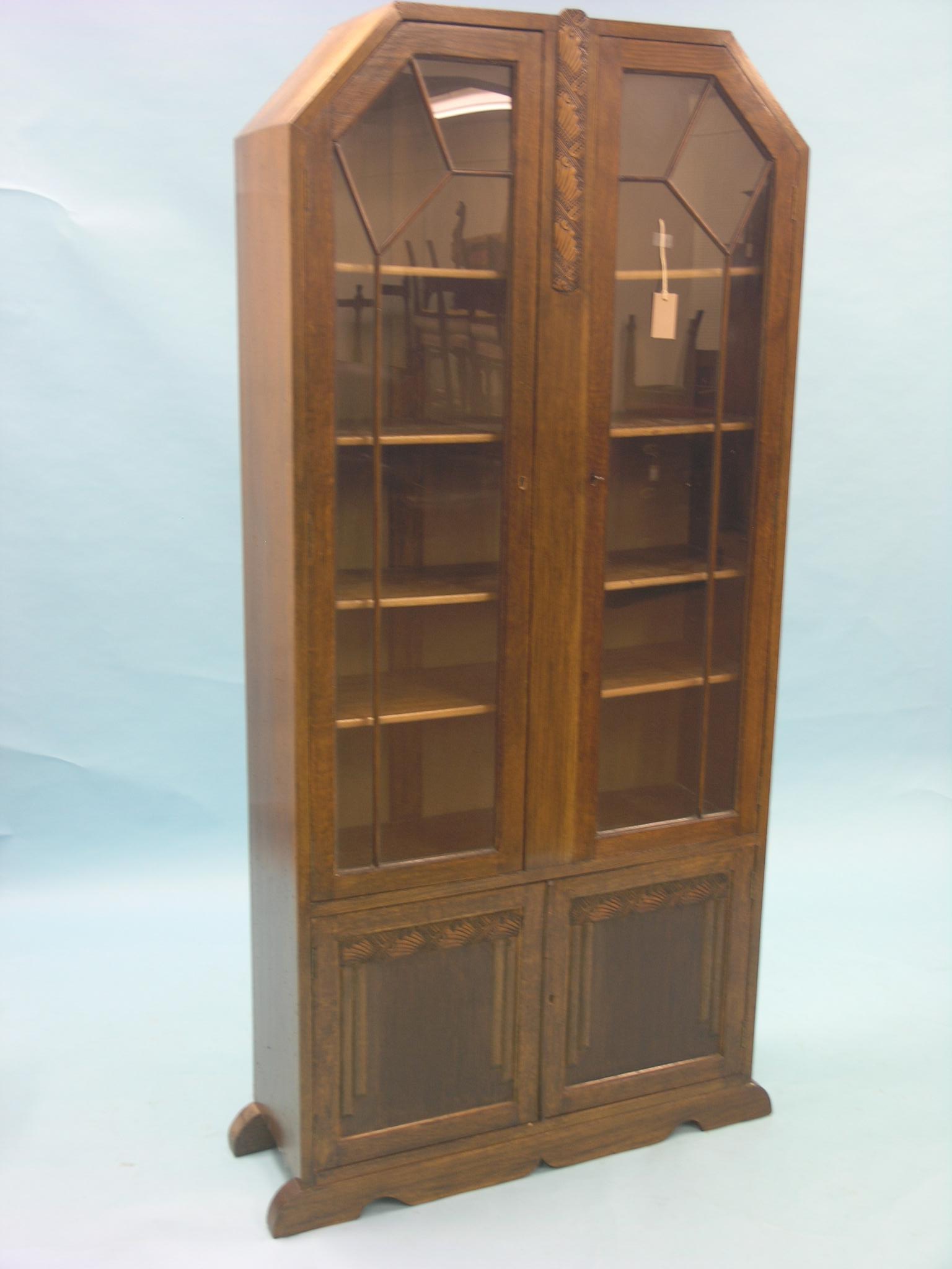 A dark oak tall bookcase, pair of glazed doors enclosing four adjustable shelves, panelled