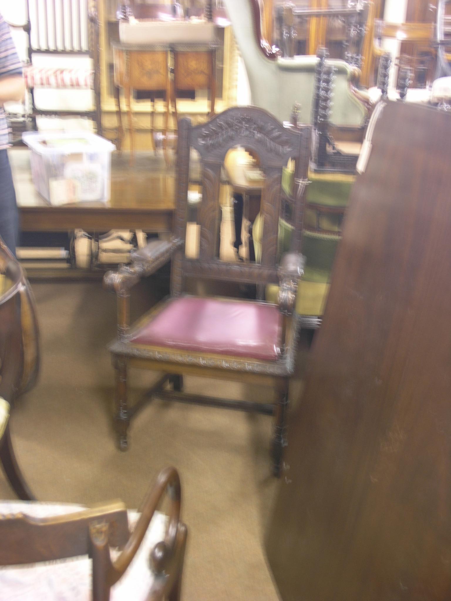 A late Victorian oak hall armchair, carved with leafage, arms with scroll terminals, drop-in seat