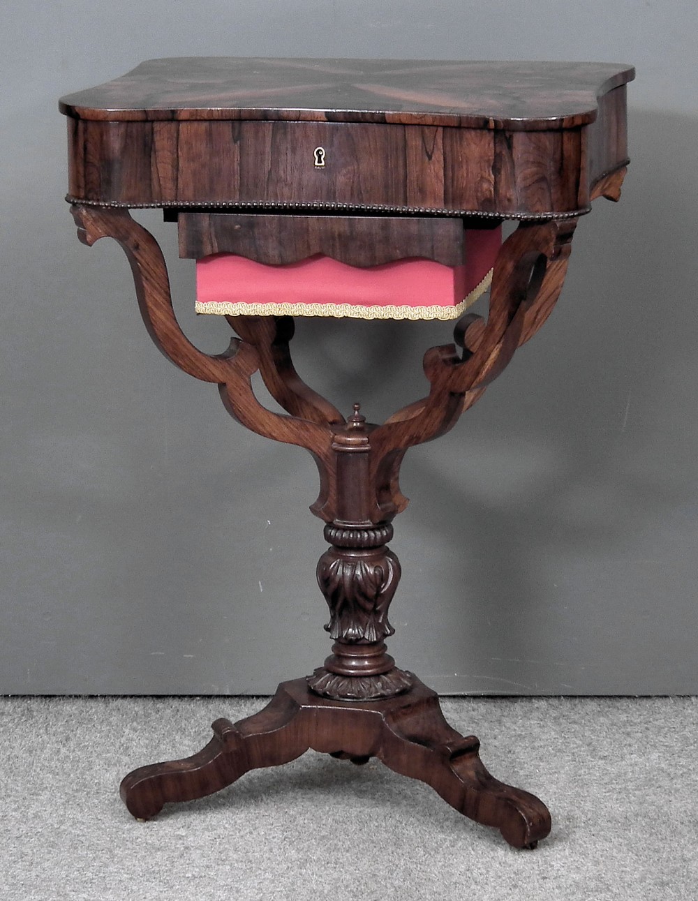 A 19th Century French rosewood rectangular work table of shaped outline, the lifting top with wide