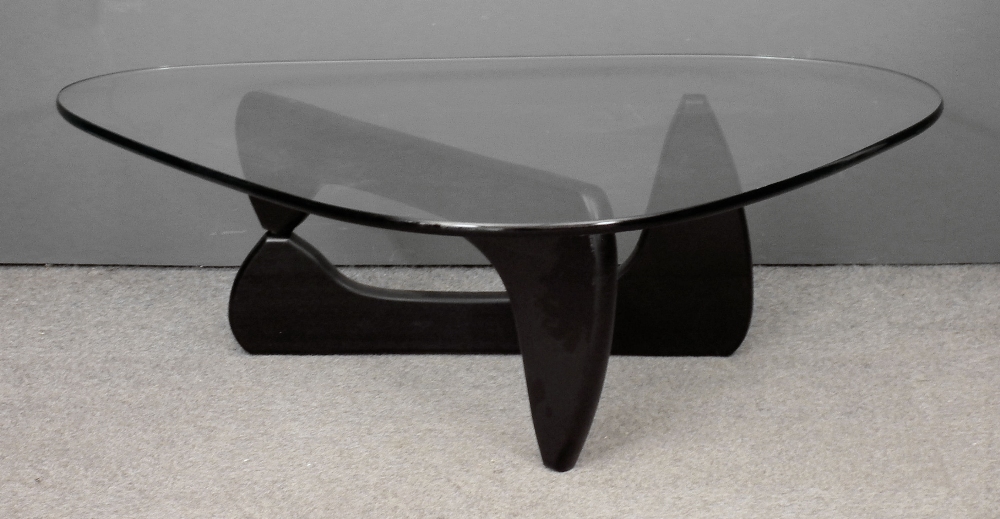 A modern plate glass and ebonised wood coffee table of rounded triangular design by Vitra Design