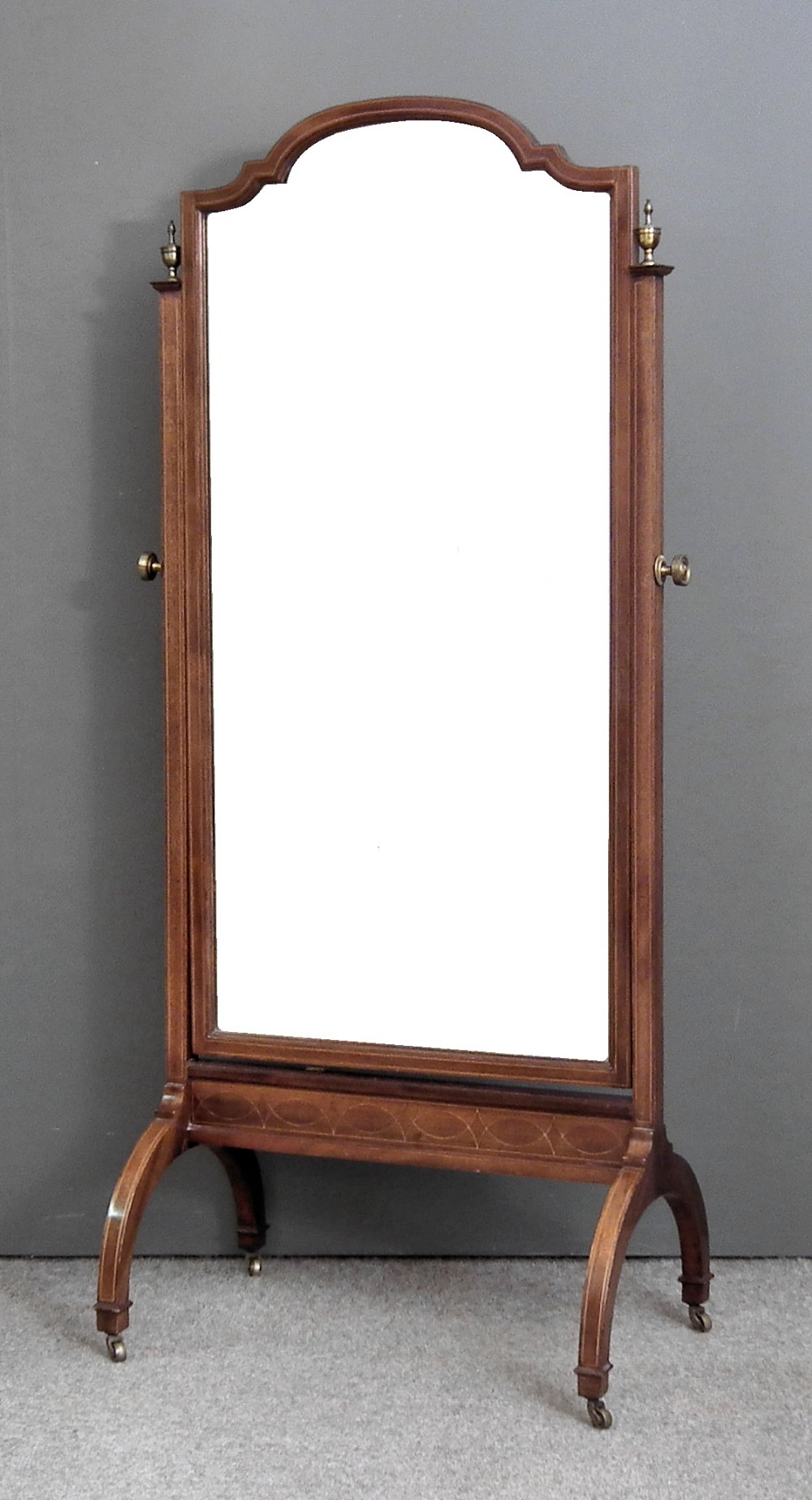 An Edwardian mahogany framed cheval mirror inlaid with boxwood stringings and with bevelled mirror