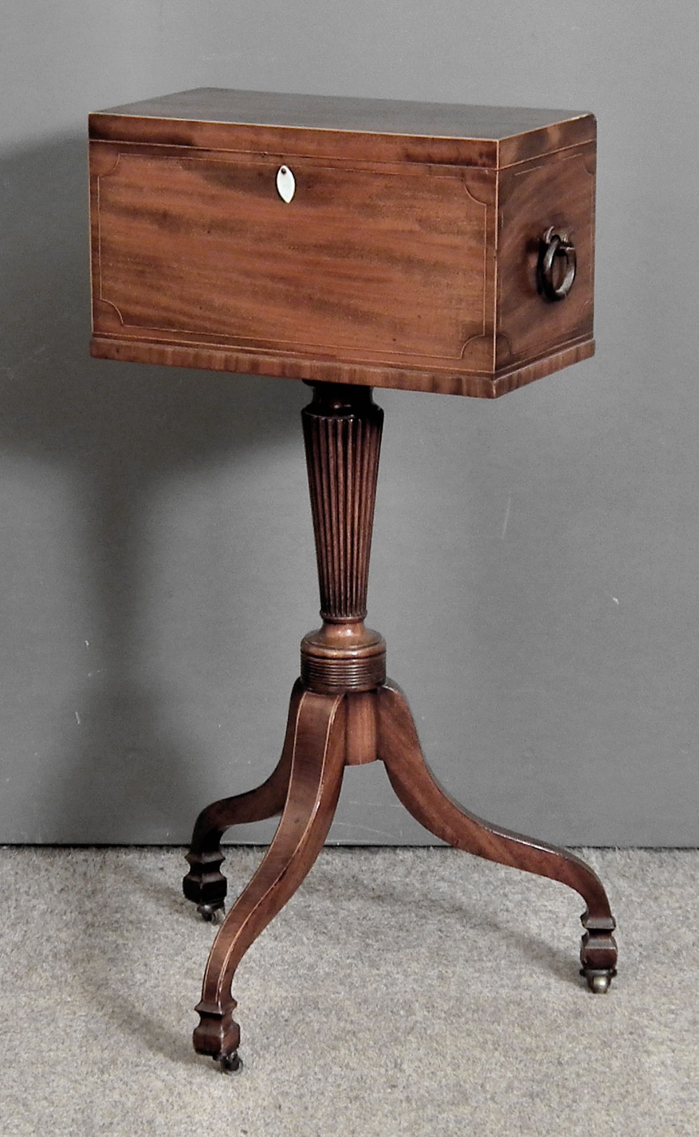A George IV mahogany rectangular two-handled teapoy inlaid with boxwood stringing, fitted two lidded