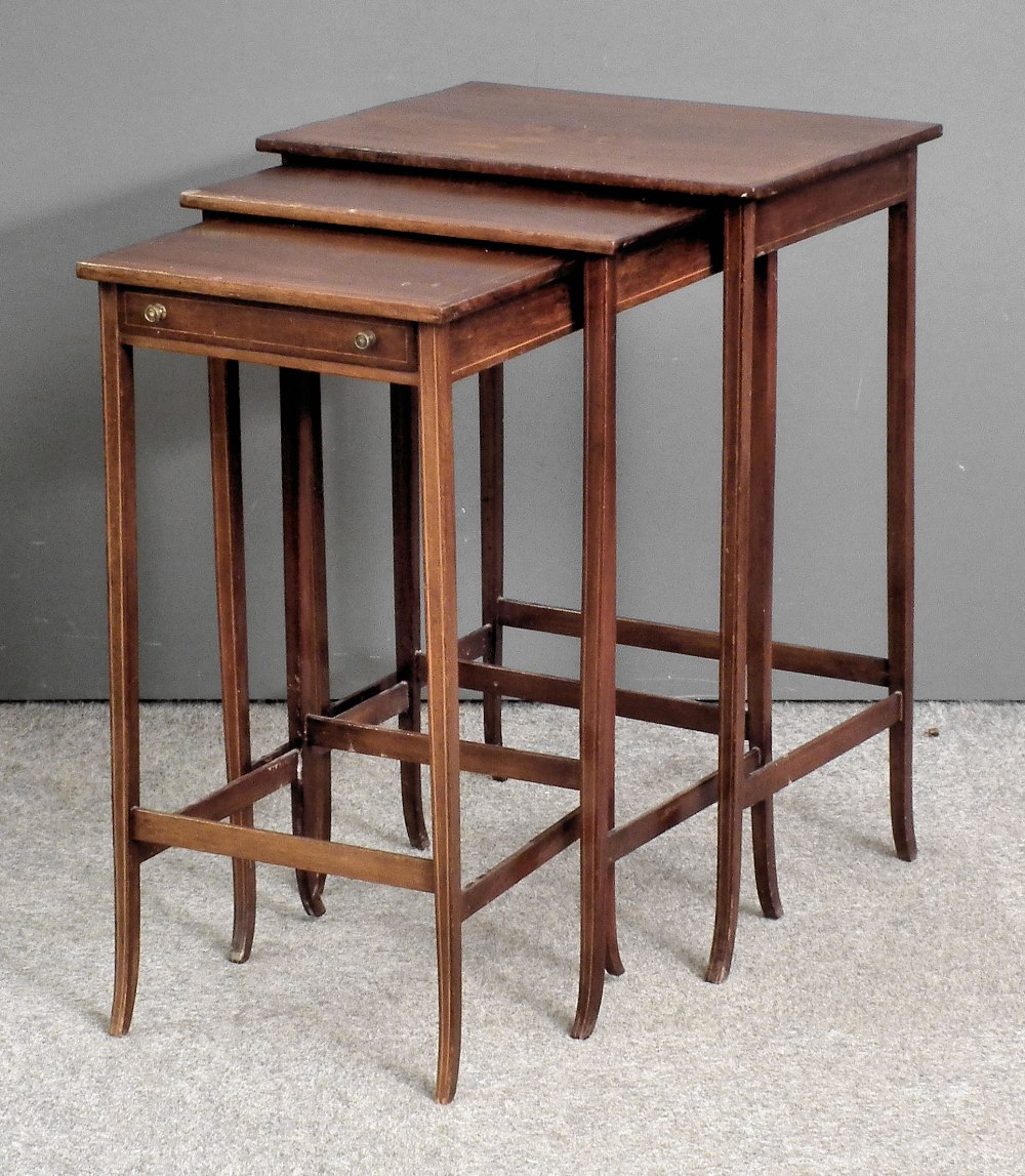 A nest of three Edwardian inlaid mahogany rectangular occasional tables, the smallest fitted