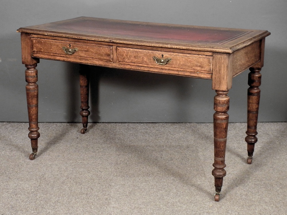 A Victorian oak writing table, the top inset with red leather, fitted two frieze drawers, on