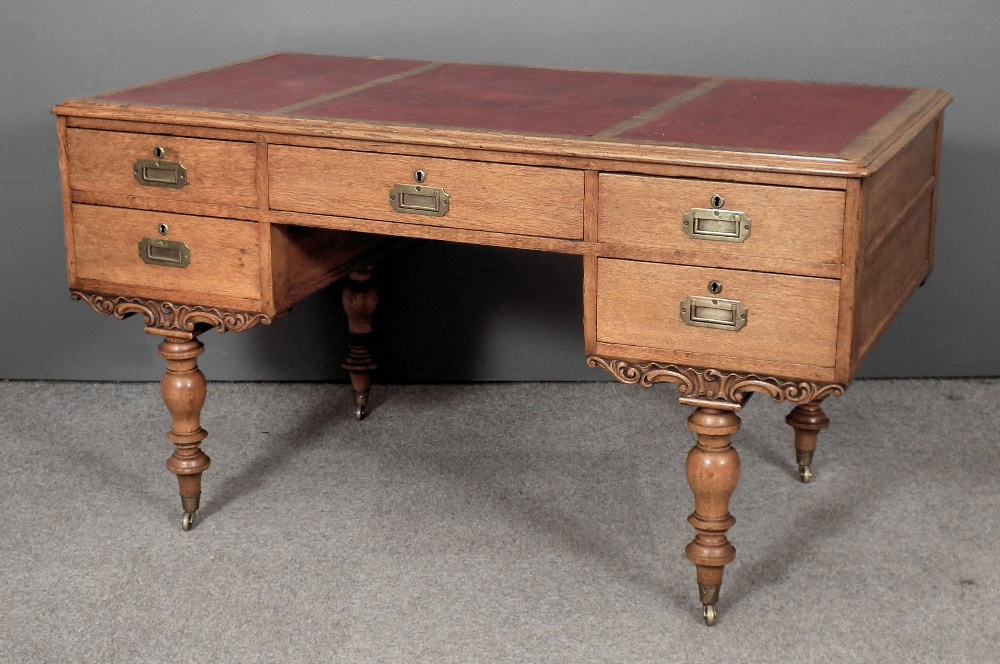 A Victorian oak “Campaign” desk, the top with moulded edge and inset with red leather cloth,