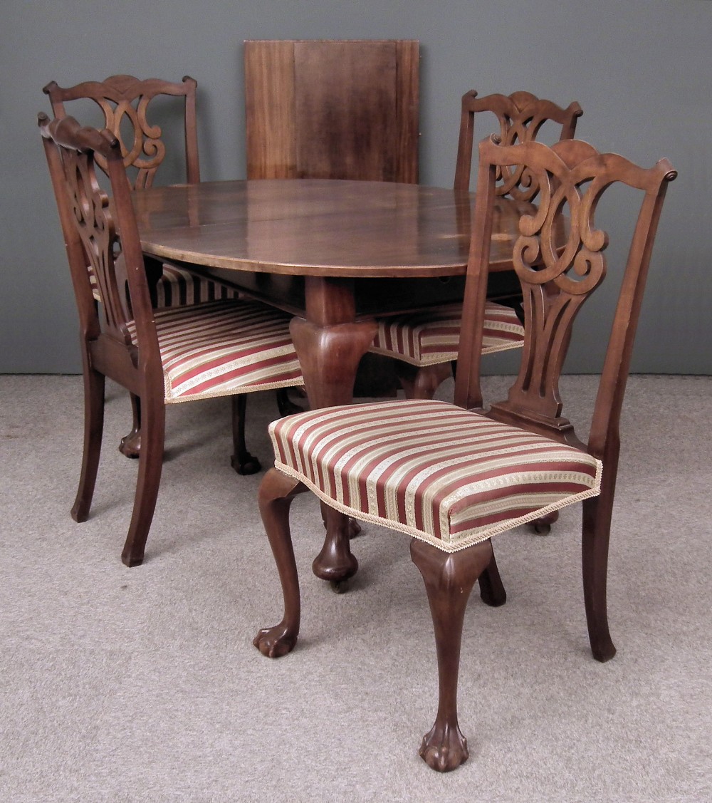 A 1930s mahogany oval extending dining table with two extra leaves for same, on bold cabriole