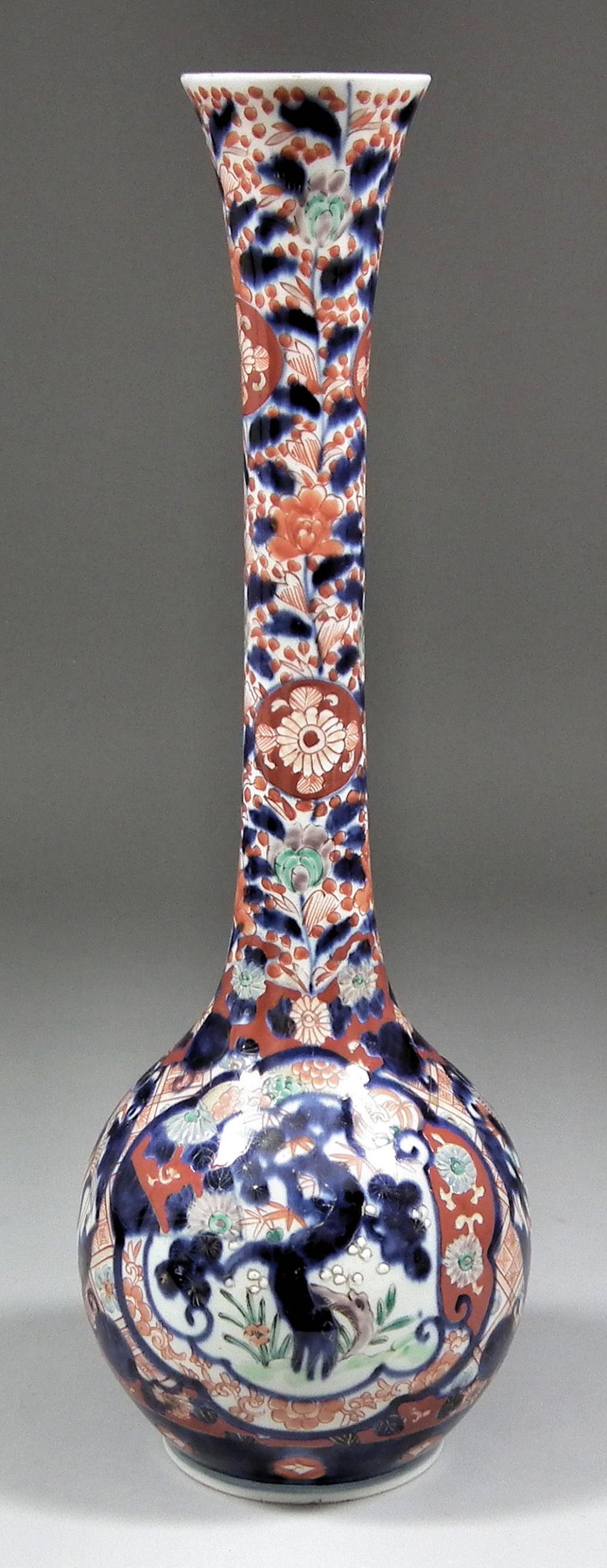 A Japanese porcelain bulbous vase with tall narrow neck decorated in the "Imari" palette with