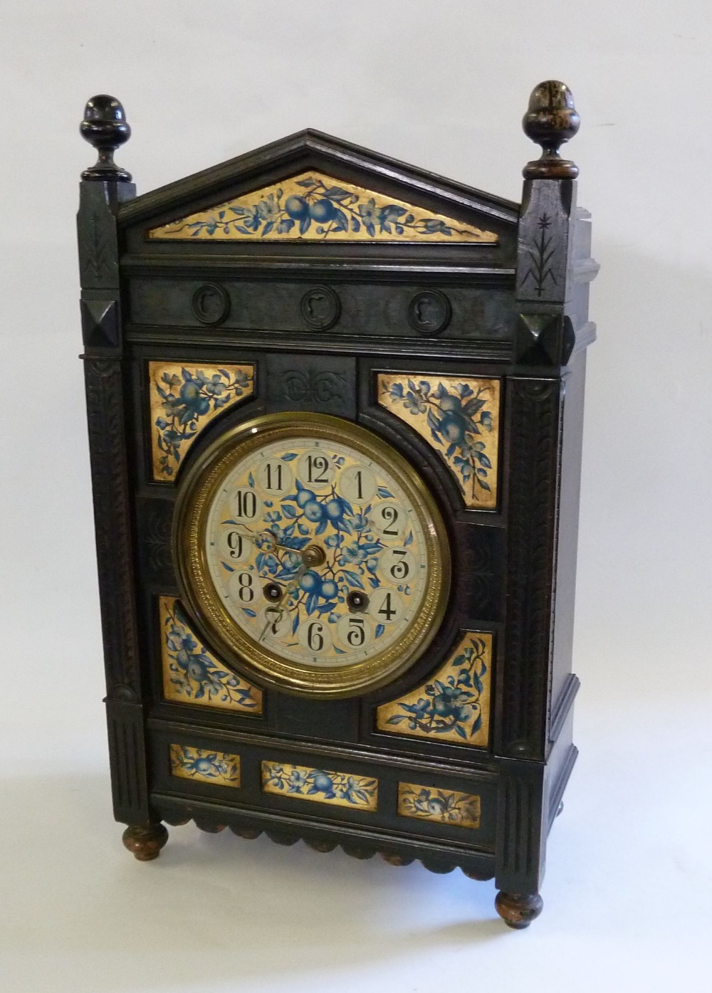 LATE VICTORIAN AESTHETIC MOVEMENT MANTEL CLOCK, the ebonised case carved with plumed corner