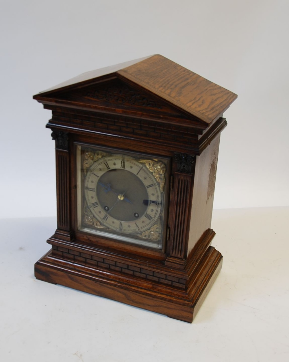 AN EDWARDIAN OAK CASED MANTLE CLOCK, of architectural form with `faux` brickwork, fluted