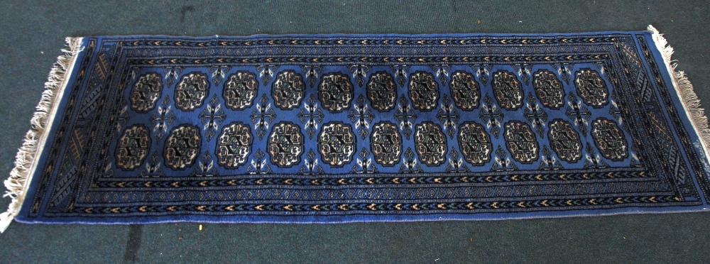 PAKISTANI `BOKHARA` RUNNER with two rows of guls on a blue field, multiple narrow border stripes, 6`