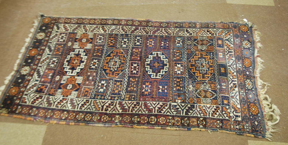 SHIRAZ PERSIAN RUG, with central row of four octagonal and latch hook decorated medallions, on a