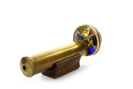 A Victorian brass kaleidoscope, with tubular shaft with eyepiece and twin rotating stained glass