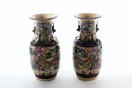 A pair of 1920s Japanese Export ware vases, decorated in the famille rose palette with scenes of