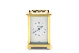 A 20th century French brass carriage clock, the white dial with black Roman numerals, retailed by