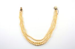 A three row cultured pearl necklace on 9ct gold snap clasp set with graduated cultured pearls,