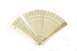 An early 19th century Chinese carved ivory fan, the sticks finely carved with temples, foliage and