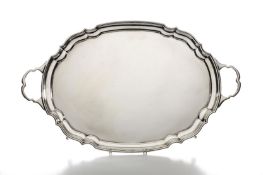 A large oval silver two handled tray, hallmarked London 1972, with pie crust rim and supported on