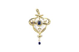 An Edwardian 15ct gold shield shaped pendant, set with numerous seed pearls and a sapphire centre