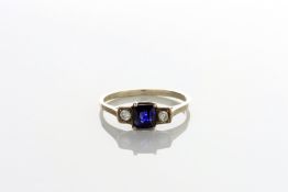 An Art Deco style three stone ring with centre square shaped sapphire flanked by two diamonds,