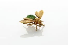 An 18ct gold brooch in the form of a bee 1950s, with a cabouchon jade body and chased wings,