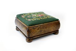 A large walnut footstool, circa 1900, raised on four bun feet, with lockable compartment, width 46cm