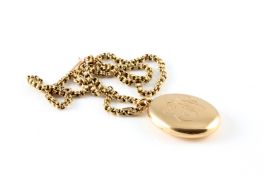 A 15ct gold Victorian oval photograph locket, the front engraved with initials E.W. on a gold