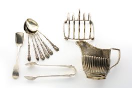 A small collection of silver, comprising a single miniature toast rack, a cream jug, six