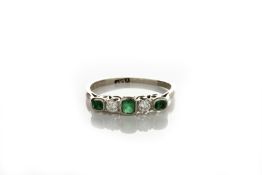 A platinum set five stone ring set with three emeralds and two diamonds, in closed setting, size ‘R’