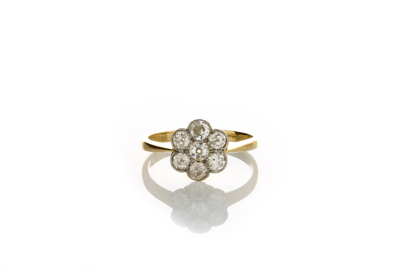 An 18ct gold diamond cluster ring, set with seven small diamonds, in closed setting, size ‘I ½’