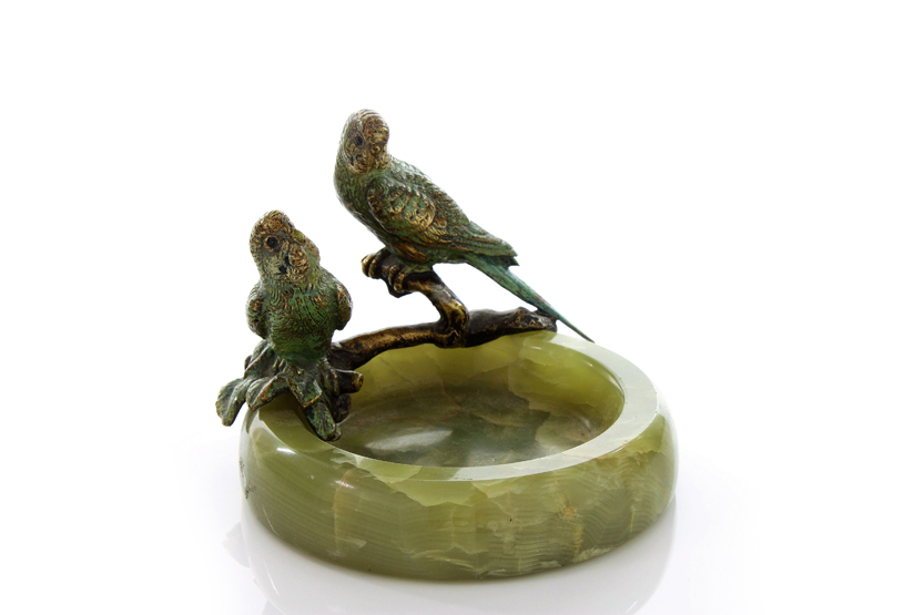 A 1930s cold painted bronze and onyx pin tray, crested with a pair of parakeets on branches and