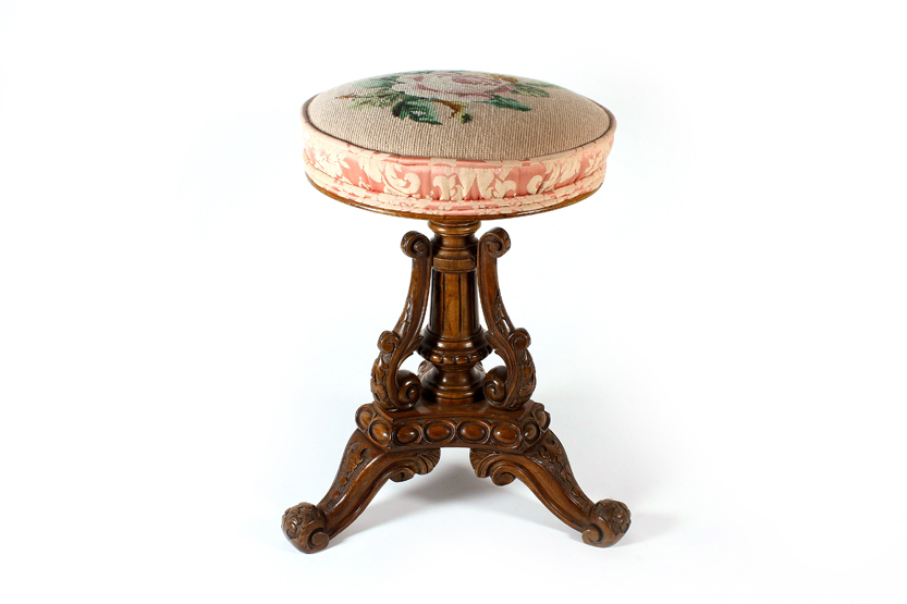 A heavily carved walnut piano stool, late Victorian, with adjustable height and tripod scroll