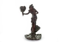 An Art Nouveau spelter table lamp, formed as a a robed woman holding a flower head sconce, and