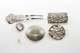 A group of four silver brooches and a silver hair pin, comprising a circular celtic brooch, tribal