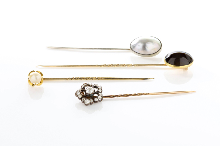 A small collection of four stick pins comprising, a stick pin set with old mine diamonds in a