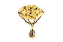 A mid Victorian oval interlaced swirl shaped brooch set with cabochon garnets and a large cabochon