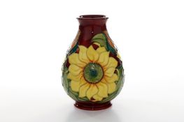 A modern Moorcroft ‘Sunflower’ pattern vase, of bulbous form with tubelined decoration on a red