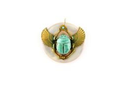 An Egyptian circular mother of pearl pendant with gilt metal decoration of a scarab beetle