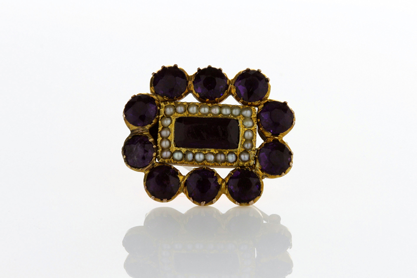 A Georgian memorial brooch, set with faceted amethyst and seed pearls in gold setting, in fitted