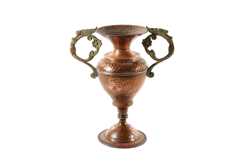 An Art Nouveau hammered copper vase, with twin caryatid handles and bulbous body supported on a