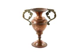 An Art Nouveau hammered copper vase, with twin caryatid handles and bulbous body supported on a