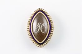 An early Georgian oval mourning brooch, set with blue and white enamel surrounded by seed pearls,