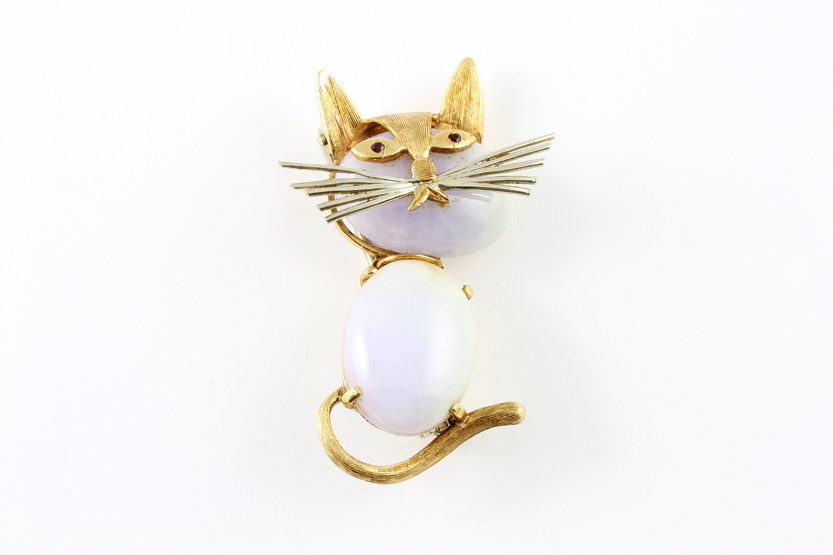 An 18ct gold brooch in the form of a cat 1950s, with white agate body and ruby eyes, height 4cm