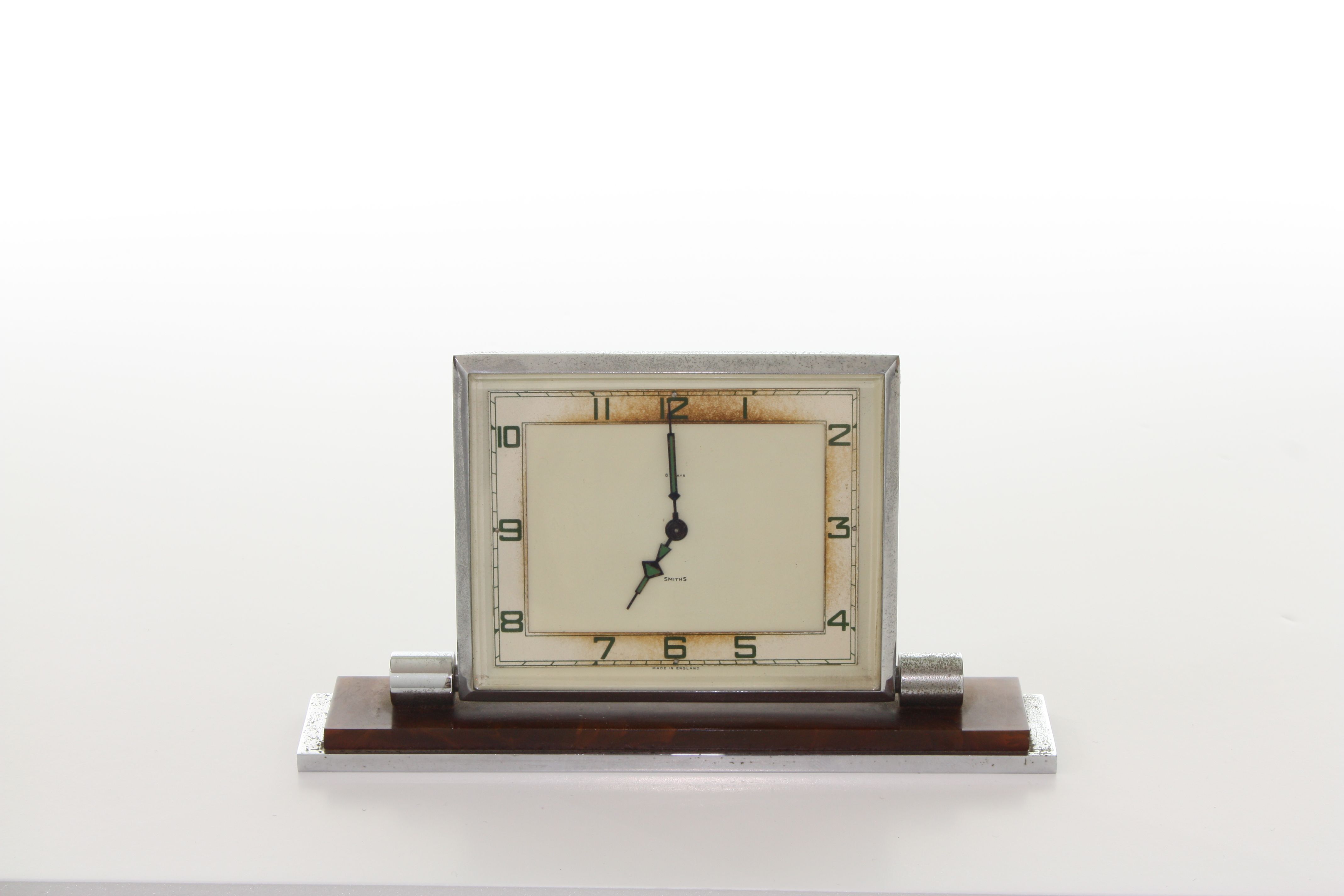 A Smiths Art Deco small mantel clock, with square cream dial and green numerals, in a chromed and