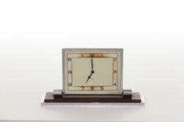 A Smiths Art Deco small mantel clock, with square cream dial and green numerals, in a chromed and