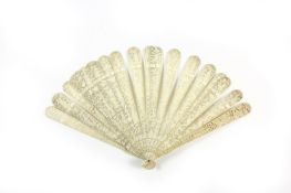An early 19th century Chinese carved ivory fan, the ivory sticks carved with figures, birds,
