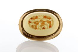 A Cantonese oval gold coloured metal brooch inset with a carved ivory panel, depicting figures under