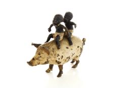 A cold painted bronze model of a pig with two African boys riding astride, probably Austrian, late